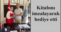 Kitabını imzalayarak hediye etti