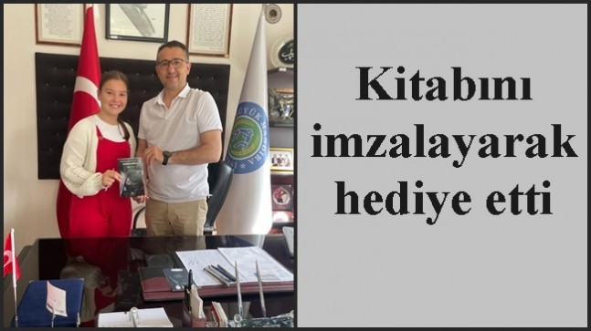 Kitabını imzalayarak hediye etti